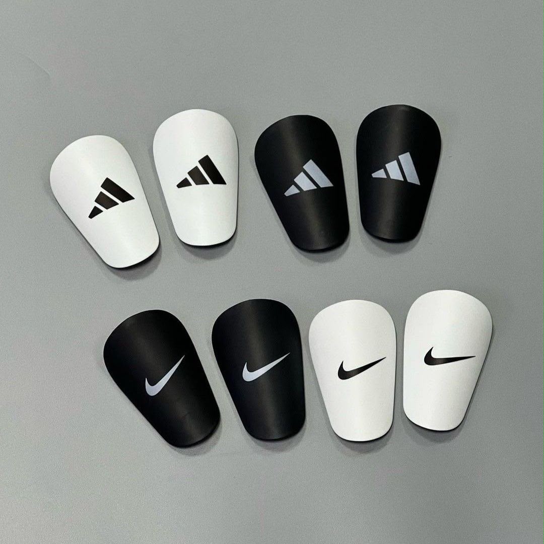 Four pairs of mini shin guards in white and black